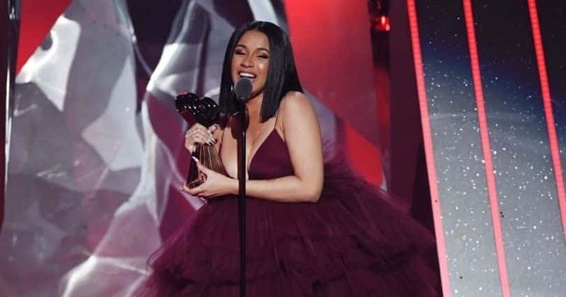 Cardi B confirms pregnancy rumors by showing off her baby bump in a skin-tight white gown on SNL