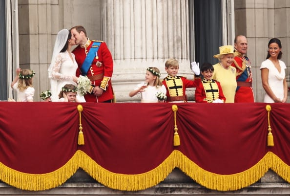 Their Royal Highnesses Prince William Duke of Cambridge and Catherine Duchess of Cambridge kiss from the balcony at Buckingham Palace on April 29, 2011 in London, England. The marriage of the second in line to the British throne was led by the Archbishop of Canterbury and was attended by 1900 guests, including foreign Royal family members and heads of state. Thousands of well-wishers from around the world have also flocked to London to witness the spectacle and pageantry of the Royal Wedding. (Photo by Paul Gilham/Getty Images)