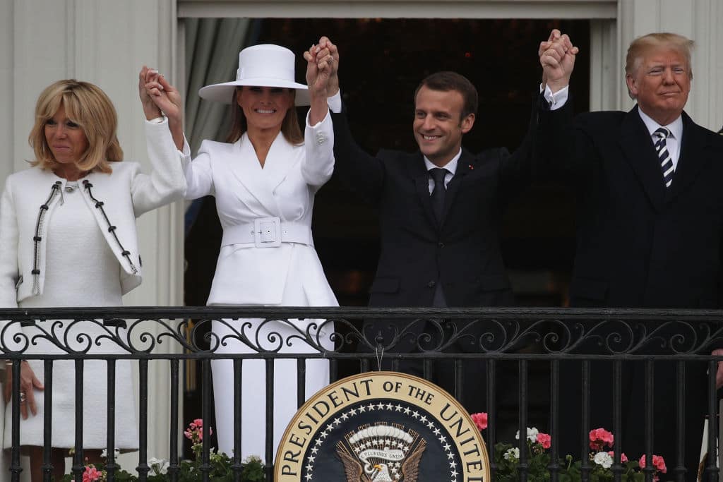 U.S. President Donald Trump (R) and first lady Melania Trump (2nd L), French President Emmanuel Macron (3rd L) and his wife Brigitte Macron (L) hold up their hands during a state arrival ceremony at the White House April 24, 2018 in Washington, DC. (Photo by Alex Wong/Getty Images)
