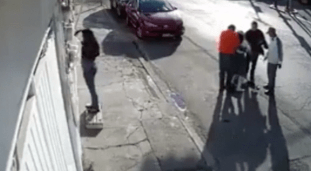 Passers-by gather around the girl to help her get back on her feet and check if she's okay. (Screenshot)