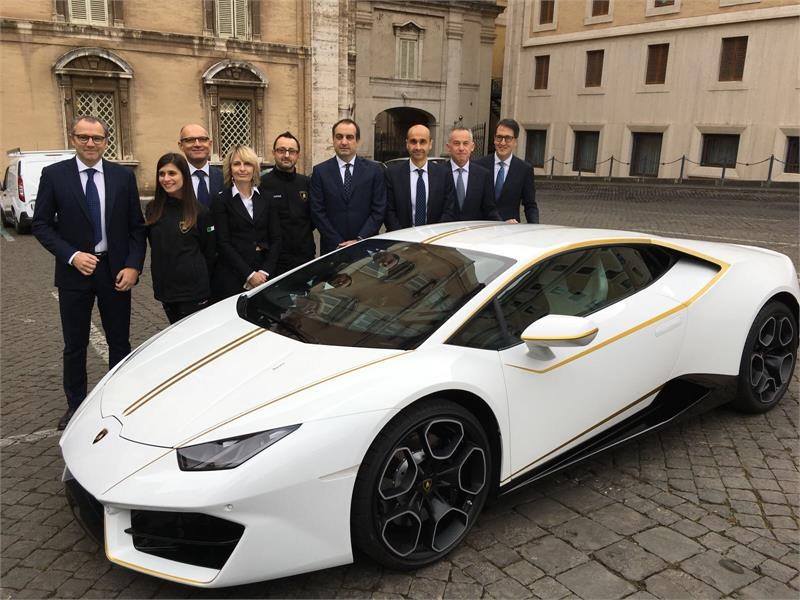 Lamborghini officials pose with their gift to Pope Francis. (Facebook)