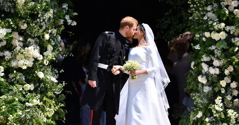 Breaking another tradition: Harry and Meghan do away with the balcony and kiss under floral archway instead