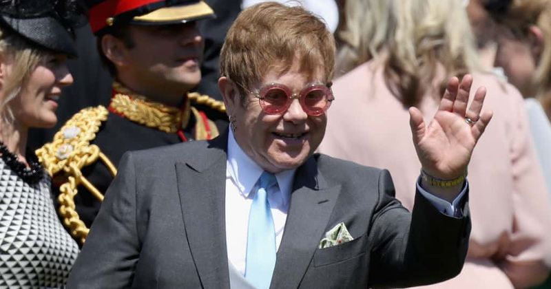 Elton John licks his lips after kissing David Beckham on the mouth at the royal wedding