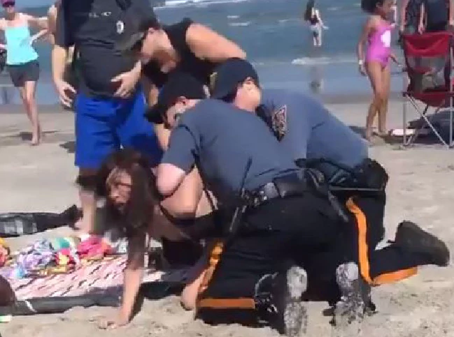 'You're not allowed to hit me like that,' Weinman repeatedly tells the officers who continue to hold her down and proceed to handcuff the young woman. (Screengrab)