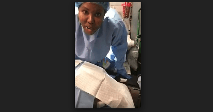 Dr. Windell Boutte speaks to the camera while a patient lies on the operating table. (YouTube/screenshot)