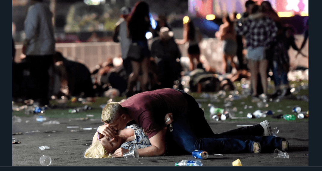A man covers a woman's body to protect her from gunfire during the Las Vegas shooting. (Getty Images)