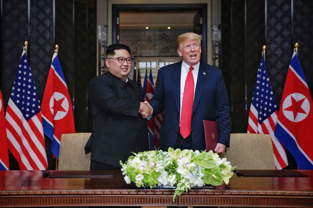In this handout photograph provided by The Strait Times, North Korean leader Kim Jong-un with US President Donald Trump during their historic US-DPRK summit at the Capella Hotel on Sentosa island on June 12, 2018 in Singapore (Getty Images)