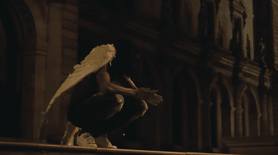 The opening shot of the video sees a black angel sitting in front of the Louvre in Paris (YouTube)