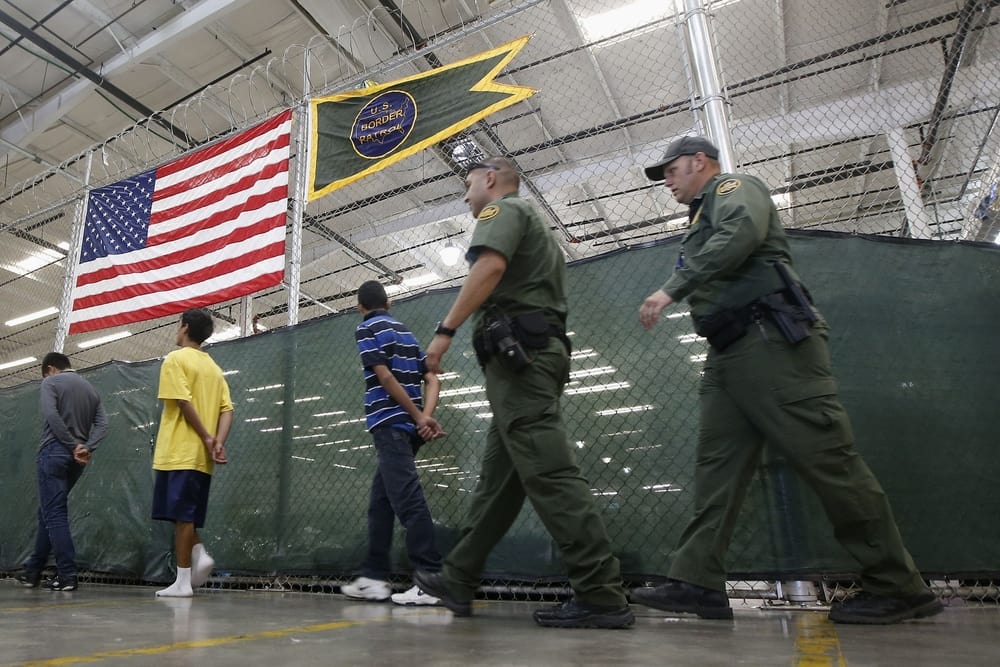 Detainees are escorted to an area to make phone calls as hundreds of mostly Central American immigrant children are being processed and held at the U.S. Customs and Border Protection Nogales Placement Center on June 18, 2014, in Nogales, Arizona. (Photo by Ross D. Franklin-Pool/Getty Images)