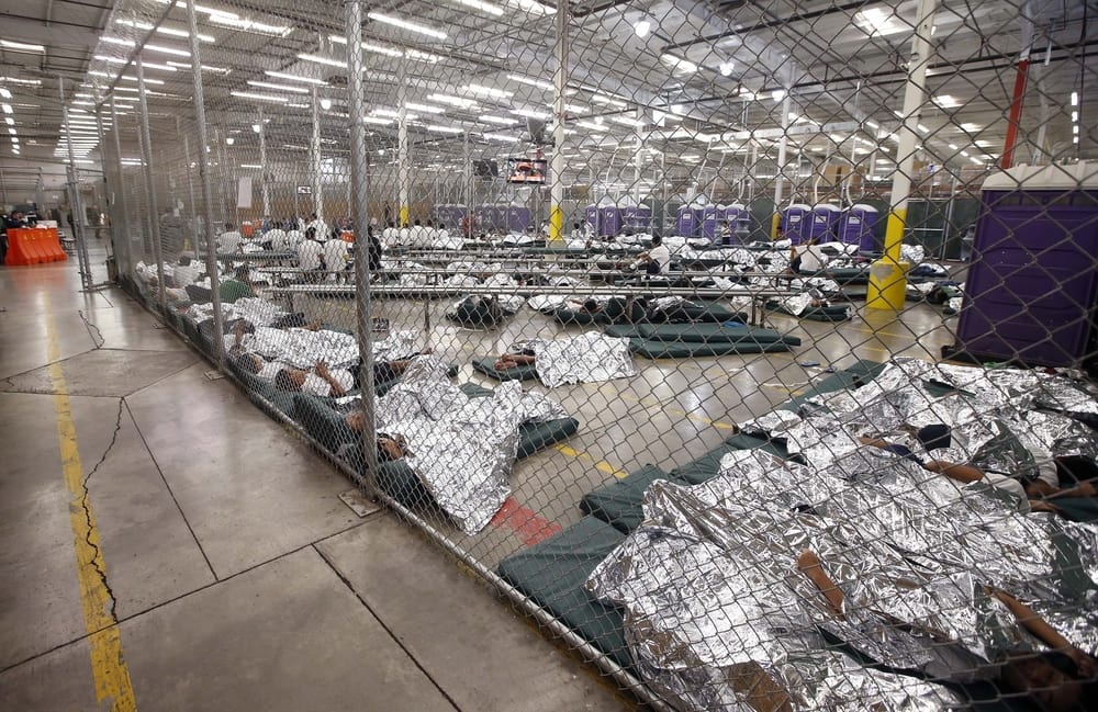 Detainees sleep and watch television in a holding cell at the US Customs and Border Protection Nogales Placement Center on June 18, 2014, in Nogales, Arizona (Photo by Ross D. Franklin-Pool/Getty Images)