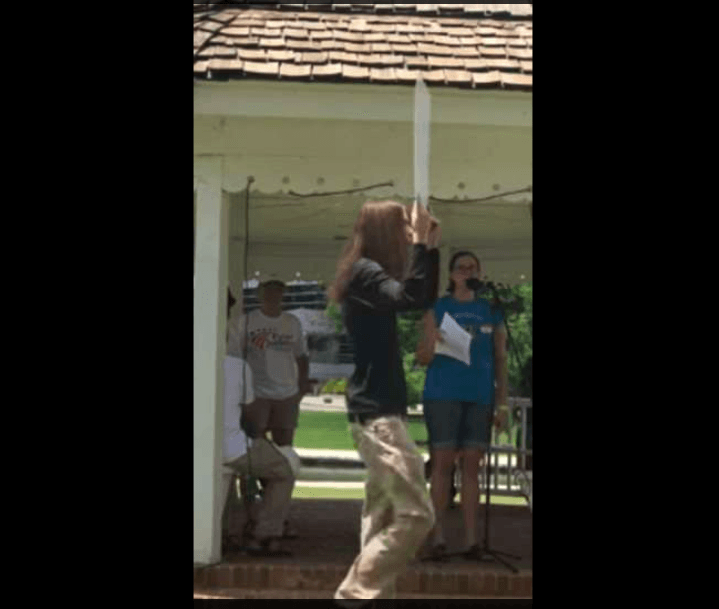 Shane Ryan Sealy can be seen walking at the site of the protest with a sign. (Twitter)