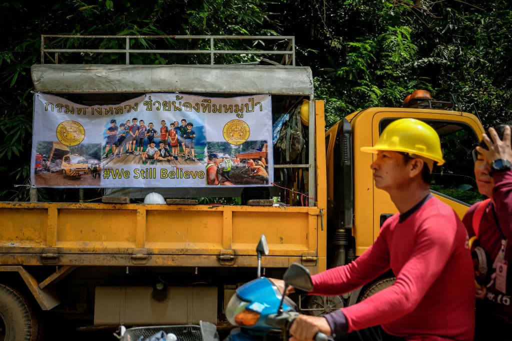 A banner hangs on the rescue shuttle bus with the photos of the missing children and their coach & the hashtag 'WE STILL BELIEVE' outside of Tham Luang Nang Non cave on July 04, 2018 in Chiang Rai, Thailand (Photo by Linh Pham/Getty Images)
