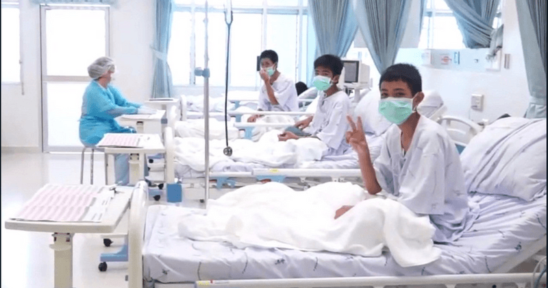Thai boys smile and wave to the camera from hospital beds in first footage after their nearly impossible rescue operation