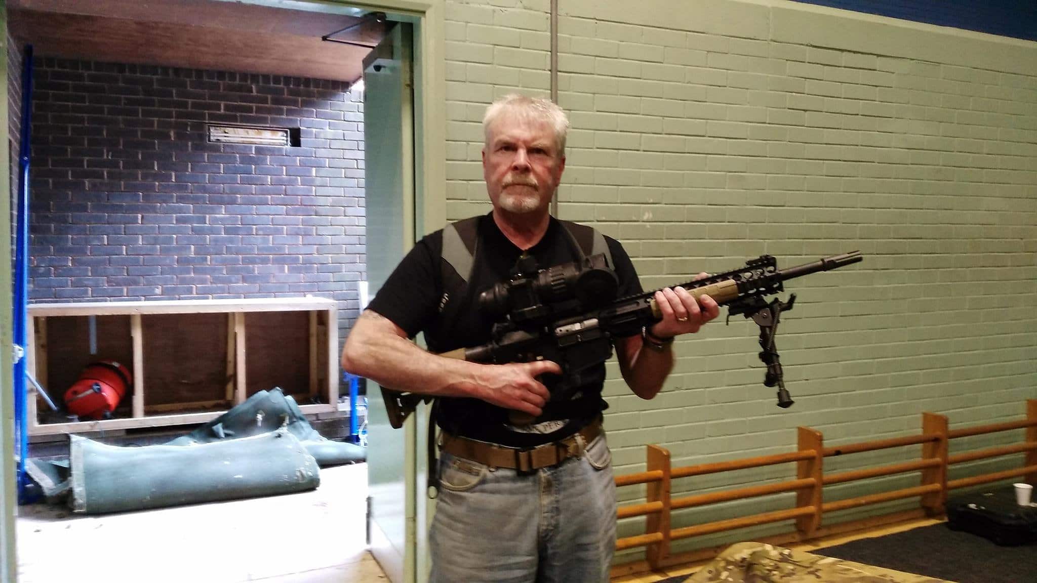 Stephen Searle, 64, is pictured holding a massive rifle (Image: SWNS)