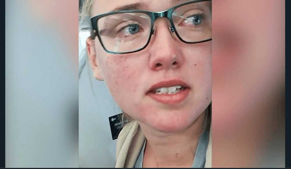 An emotional Errson looks on as some passengers slam her actions. (Facebook screenshot)