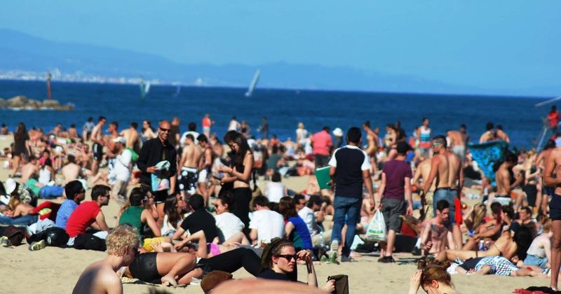 Shocking video footage shows migrants landing on packed Spanish beach and ask naked sunbathers for water