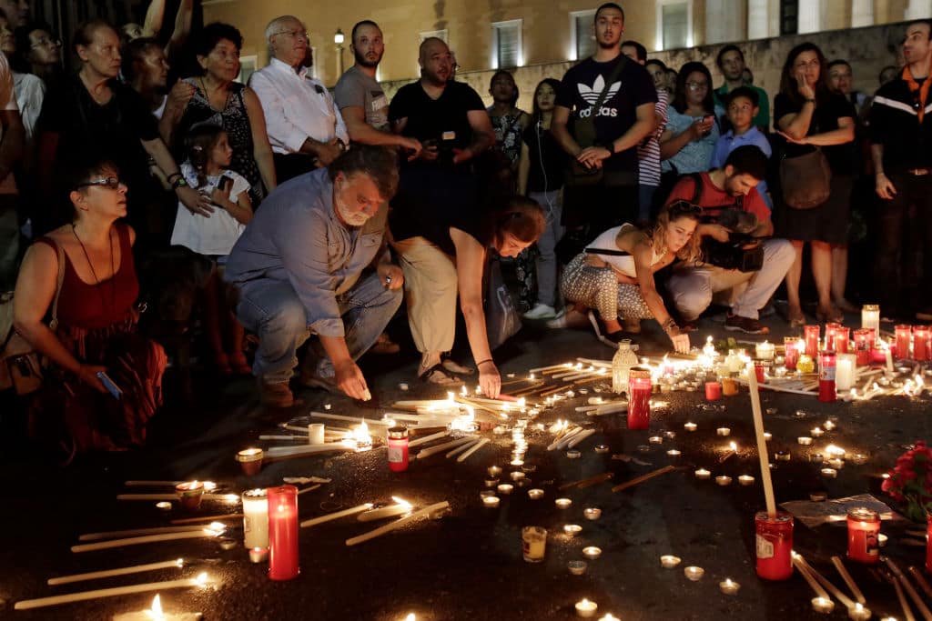 Members of the public light candles outside the Greek Parliament to commemorate the victims of the country's worst ever wildfires on July 30, 2018 in Athens, Greece. (Getty Images)
