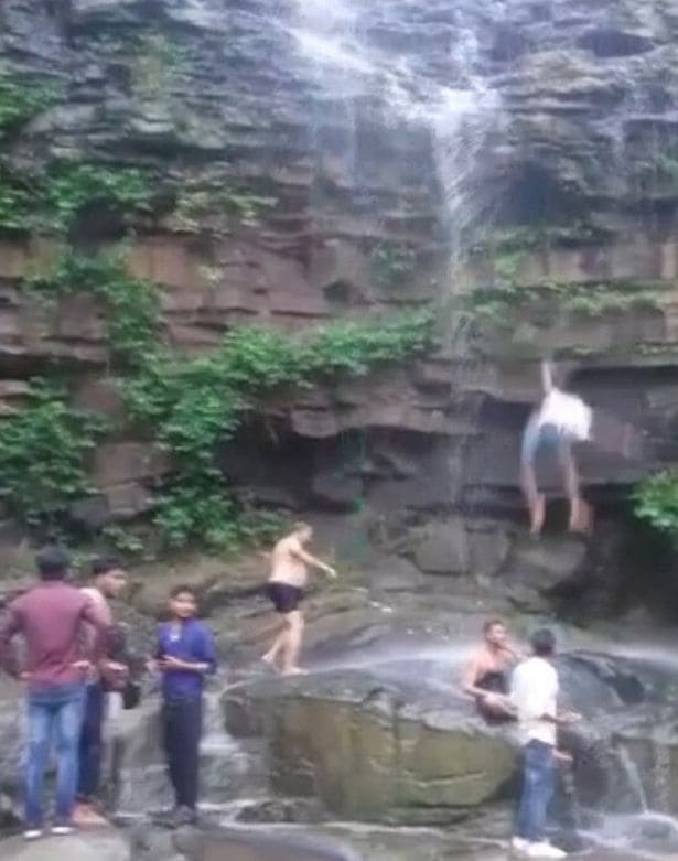 The man broke his pelvis after falling 50 feet down the waterfall in northern India. (Screenshot)