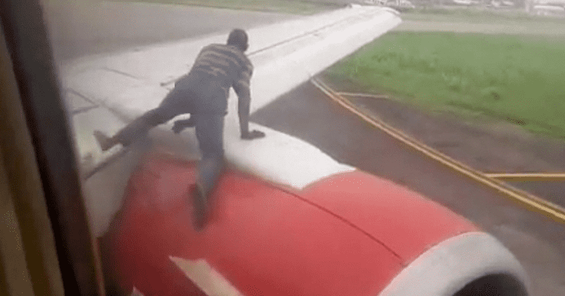 Man climbs on plane wing and tries to enter cabin as aircraft prepares for takeoff, passengers watch in horror