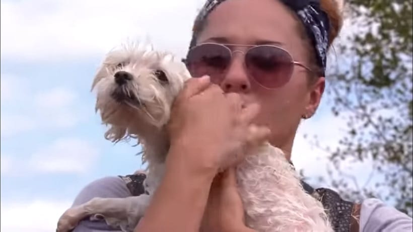 Soshe with one of his rescuers after being pulled out from the flooded house (screenshot from the video)