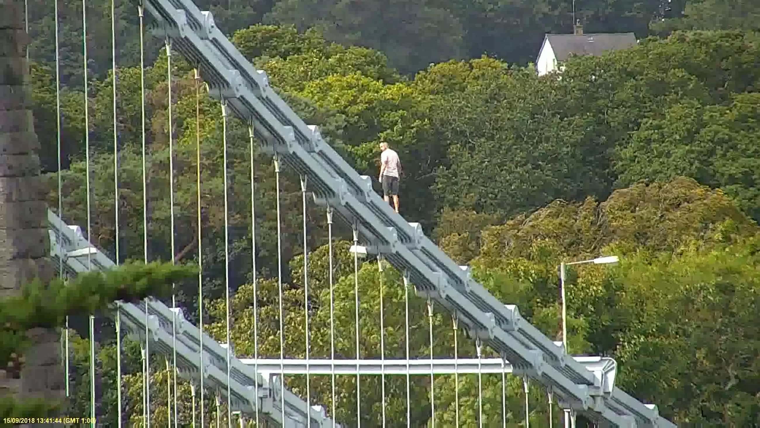 Police had to close off the bridge causing two-hour long tailbacks while Jones walked along the railings with his t-shirt off (SWNS)