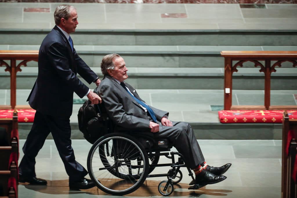 George W. Bush, left, wheels his father, George H.W. Bush into the church for the funeral for former first lady Barbara Bush at St. Martin's Episcopal Church on April 21, 2018 in Houston (Photo by Brett Coomer - Pool/Getty Images)