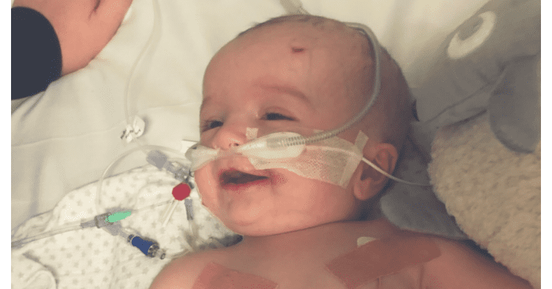 Baby with deadly heart tumor wakes up from coma to smile at father giving family hope as they raise money for surgery