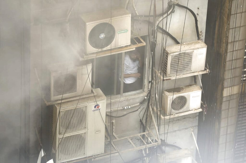 Bangladeshi, stuck in a multi-storied office building on fire, speaks on his mobile phone in Dhaka, Bangladesh, Thursday, March 28, 2019 (AP)