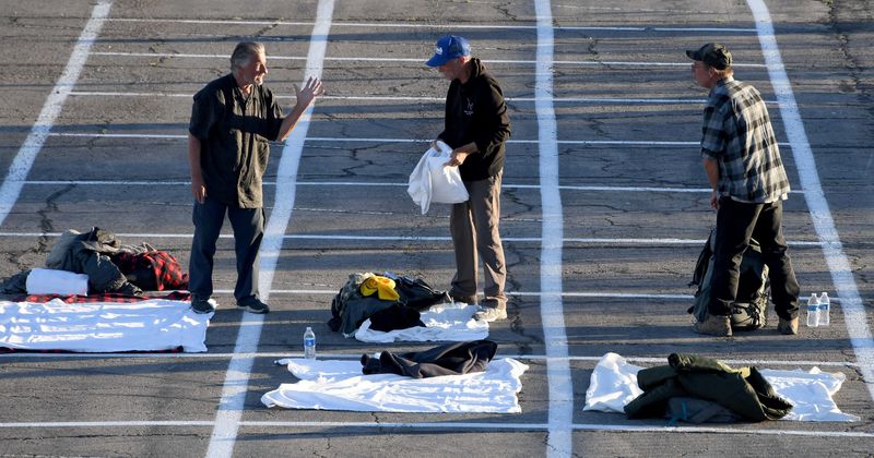 Hundreds of homeless in Las Vegas sleep six feet apart in parking lot after their shelter was hit by coronavirus