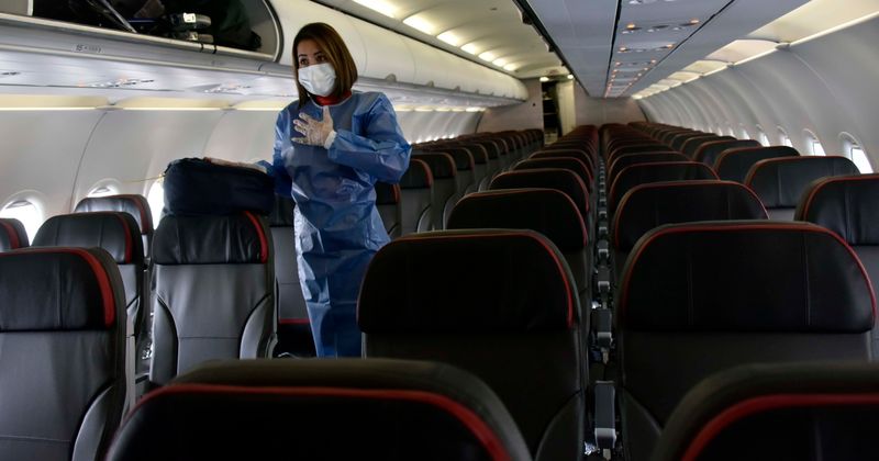 'Karen' escorted off plane for refusing to wear mask and calling flight attendant 'a**hole' as passengers cheer