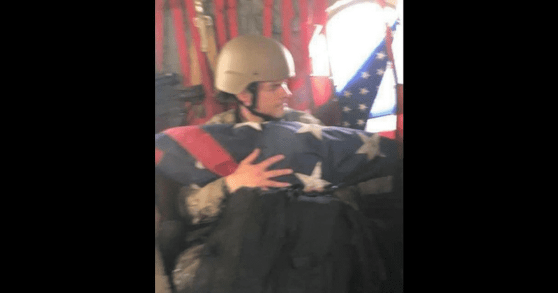 Viral photo shows soldier desperately cradling American flag on their way out of Kabul